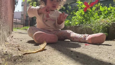2 year old child playing with a feather Stock Footage 271735106