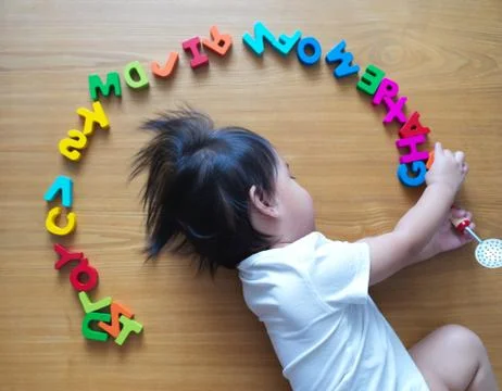 2 year old child playing with alphabets Stock Photos