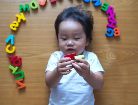 2 year old child playing with alphabets Stock Photos