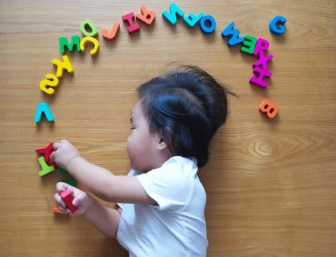 2 year old child playing with alphabets Stock Photos