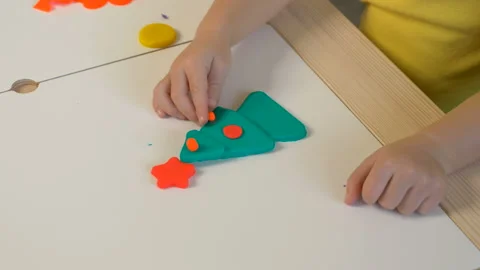 A 2-year-old preschool kid  making christmas tree from modeling clay (compound) Stockbeeldmateriaal 99415782