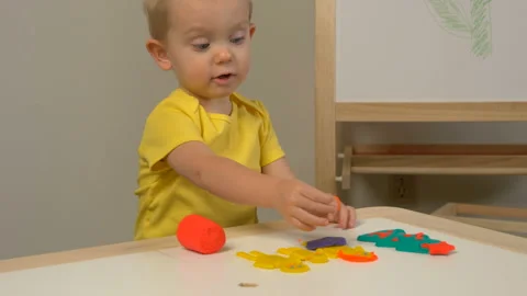 A 2-year-old preschool kid  making christmas tree from modeling clay (compound) Stockbeeldmateriaal 99448858