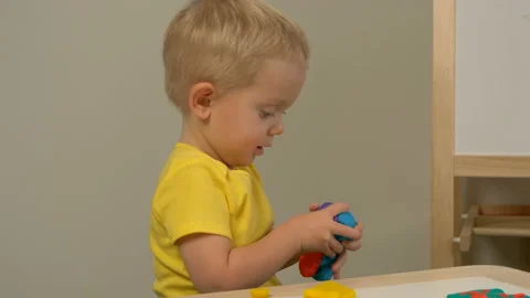 A 2-year-old preschool kid  making christmas tree from modeling clay (compound) 動画素材 99453340