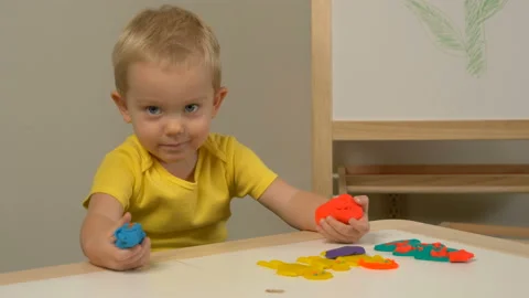 A 2-year-old preschool kid  making christmas tree from modeling clay (compound) 動画素材 99458062