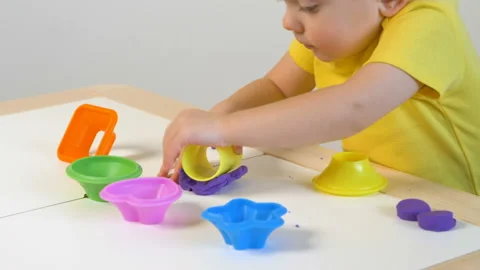 A 2-year-old preschool kid  making christmas tree from modeling clay (compound) Vídeo Stock 99524005