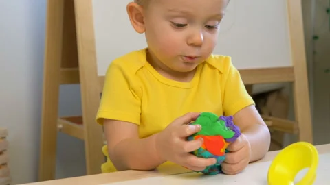 A 2-year-old preschool kid  making christmas tree from modeling clay (compound) 库存影片 99525885