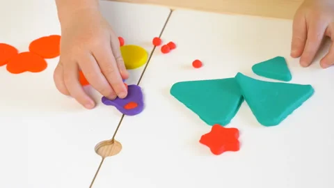 A 2-year-old preschool kid  making christmas tree from modeling clay (compound) Stockbeeldmateriaal 99530652