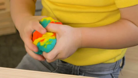 A 2-year-old preschool kid  making christmas tree from modeling clay (compound) Vídeo Stock 99531263