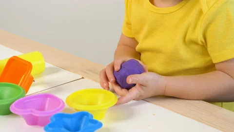 A 2-year-old preschool kid  making christmas tree from modeling clay (compound) Stock Footage 99531655