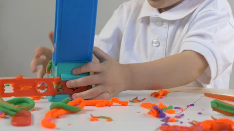 A 2-year-old preschool kid playing with modeling clay (compound) Stockbeeldmateriaal 104525645