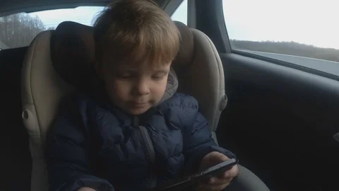 2 years baby boy using phone in the car. soft focus Stock Footage 106860258