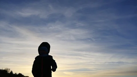 2 years old boy running forward to camera silhouette outdoors Видео 100290330