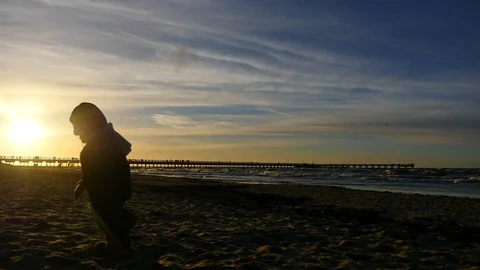 2 years old boy running along on the sand silhouette  on the beach near sea Video stock 100290342