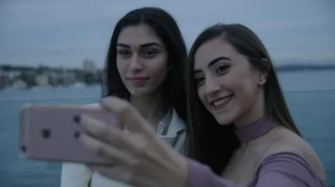 2 Young Ladies taking a selfie photo at an evening event Stock Footage 65396830