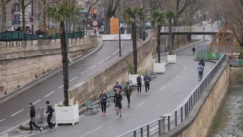 20 Rainy gray winter day Paris sports people running the Sena embankment in t Stock Footage 100814048