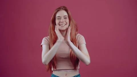 20-year-old red-haired young woman Surprised, in a pink casual T-shirt, isolated Stock Footage 150368252