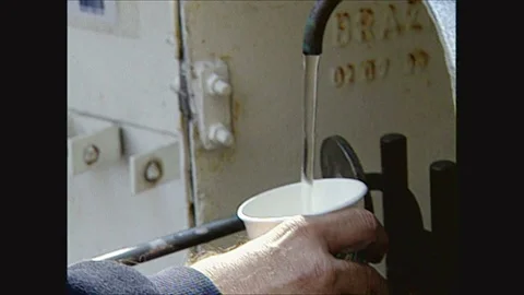 2000s: New Yorker getting water from sampling station and drinking it, boat and Stock Footage 128193760