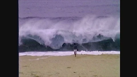 2000s: young boy in front of wave on beach, house collapsing, rushing water, Stock Footage 128194255