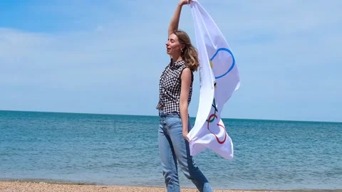 20.05.2021. Sochi. Summer Olympic Games in Tokyo. Girl with a flag on the beach Stock Footage 155034295