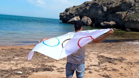 20.05.2021. Sochi. Summer Olympic Games in Tokyo. Man with a flag on the beach 库存影片 158248239