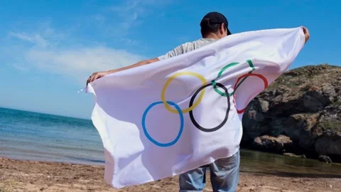 20.05.2021. Sochi. Summer Olympic Games in Tokyo. Man with a flag on the beach Stock Footage 158761455