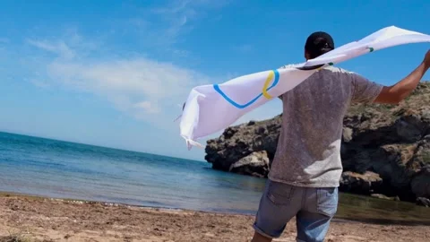20.05.2021. Sochi. Summer Olympic Games in Tokyo. Man with a flag on the beach Stock Footage 158903930