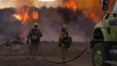 2017 - firefighters look on as a blaze burns out of control in California. Stock Footage