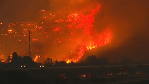 2017 - the Thomas Fire burns at night in the hills above the 101 freeway near Stock Footage 107484131