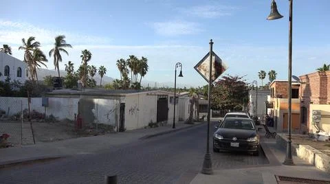 2017:LOS CABOS MEXICO.Cars Are Parallel Parked On Cobblestone Street Flanked By Fotos Stock