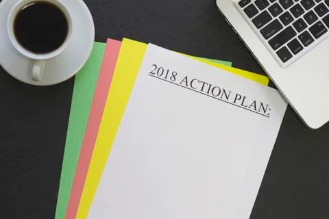 2018 action plan paper on colored paper sheets, a coffee cup and a laptop Stock Photos