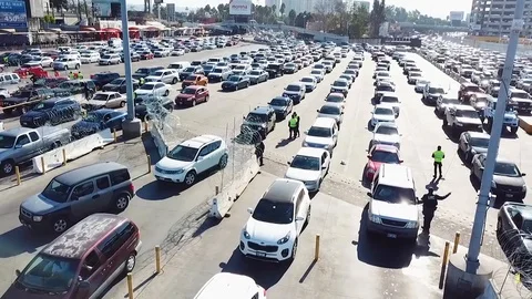 2018 - Border Patrol agents wait to inspect a line of cars at the San Ysidro Stock-Footage 100119008