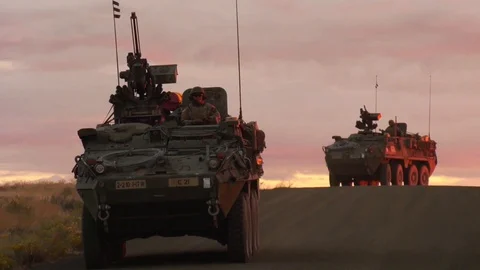 2018 - a convoy of US military vehicles travels at sunset or sunrise in a Stock Footage
