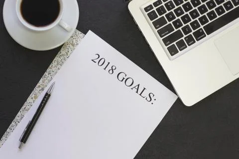 2018 goals paper on a patterned folder, a coffee cup and a laptop 스톡 사진