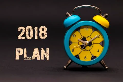2018 plan written with alarm clock on black paper background Illustrazione stock