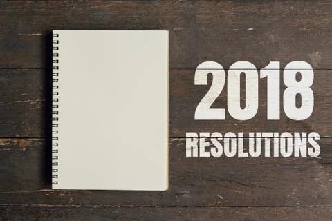 2018 Resolutions and Brown note book open on wood table background with space Stock Photos