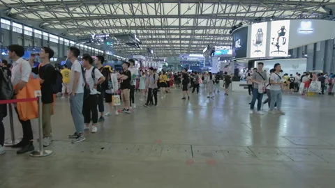 2019 Aug 04, Shanghai. Security guard walking by a crowd of attendees queuing Stock Footage 345908505
