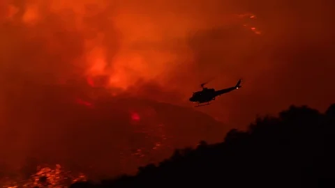 2019 - a helicopter makes a dramatic water drop at night responding to the Cave Stock Footage 120930709