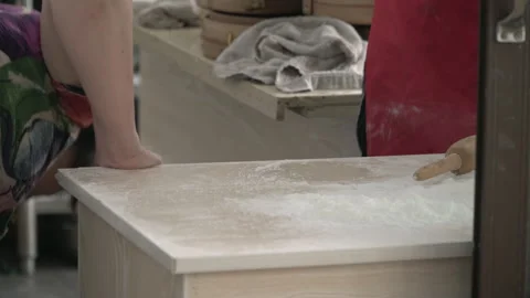 2019 Jun 08, Jiaxing. Baker stretches dough by hand on floured wooden counter Stock Footage 345394543