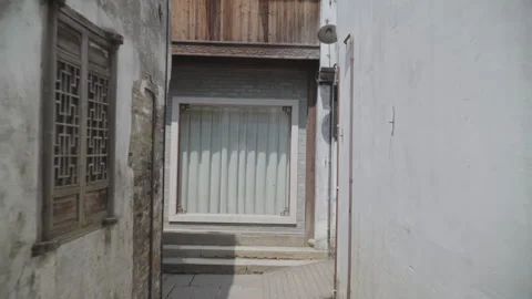 2019 Jun 08, Jiaxing. Man pushes stroller through historic sunlit alley Video stock 345414629
