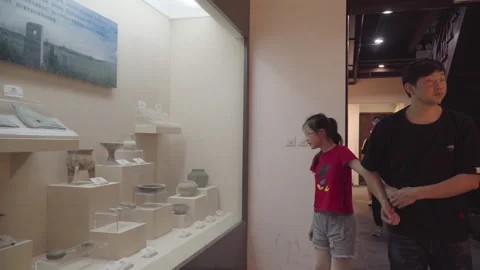 2019 Jun 08, Jiaxing. Man and girl examine ancient pottery artifacts Stock Footage 345491989