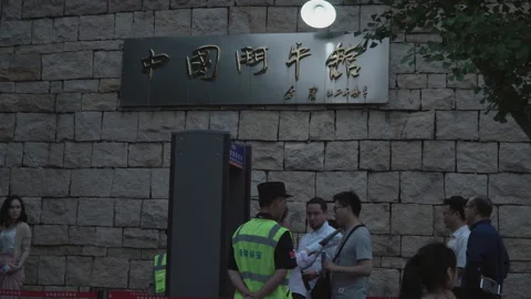 2019 Jun 08, Jiaxing. A security guard in a high-visibility vest checks visitors Stock Footage 345136761