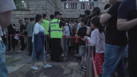 2019 Jun 08, Jiaxing. Security guard manages orderly diverse crowd waiting Stock Footage 345137340