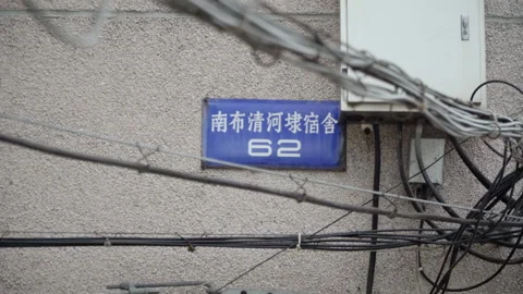 2019 Jun 08, Jiaxing. Tangled electrical wires partially obscure blue house Stock Footage 345406009
