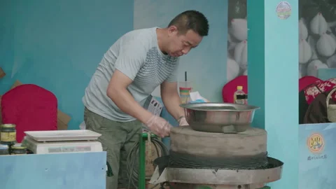 2019 Jun 09, Jiaxing. Man operating traditional electric stone grinding mill 動画素材 345585679