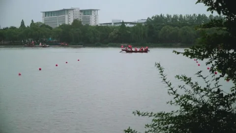 2019 Jun 10, Jiaxing. Crews paddle dragon boats on urban park lake Vídeos de archivo 338289973