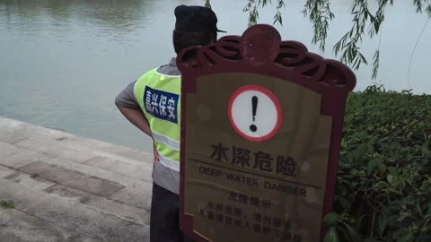 2019 Jun 10, Jiaxing. Guard by deep water danger sign at lakeside Stock Footage 338281874