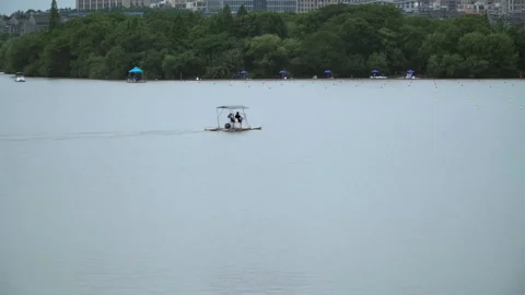 2019 Jun 10, Jiaxing. Two People Ride Covered Boat on Urban Lake 库存影片 336308014