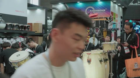 2019 Oct 13, Shanghai. Attendees and vendors browse percussion instruments Stock Footage 345923099