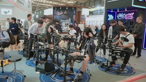 2019 Oct 13, Shanghai. Attendees test electronic drum kits Stock Footage 345923545