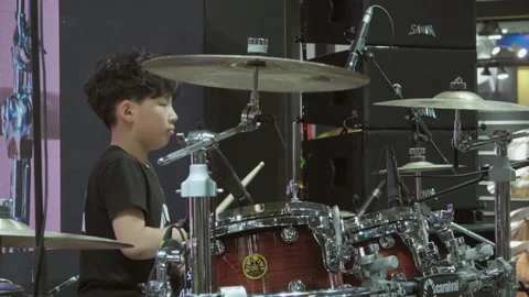 2019 Oct 13, Shanghai. Focused curly-haired boy plays wooden drum set under Stock Footage 345927846